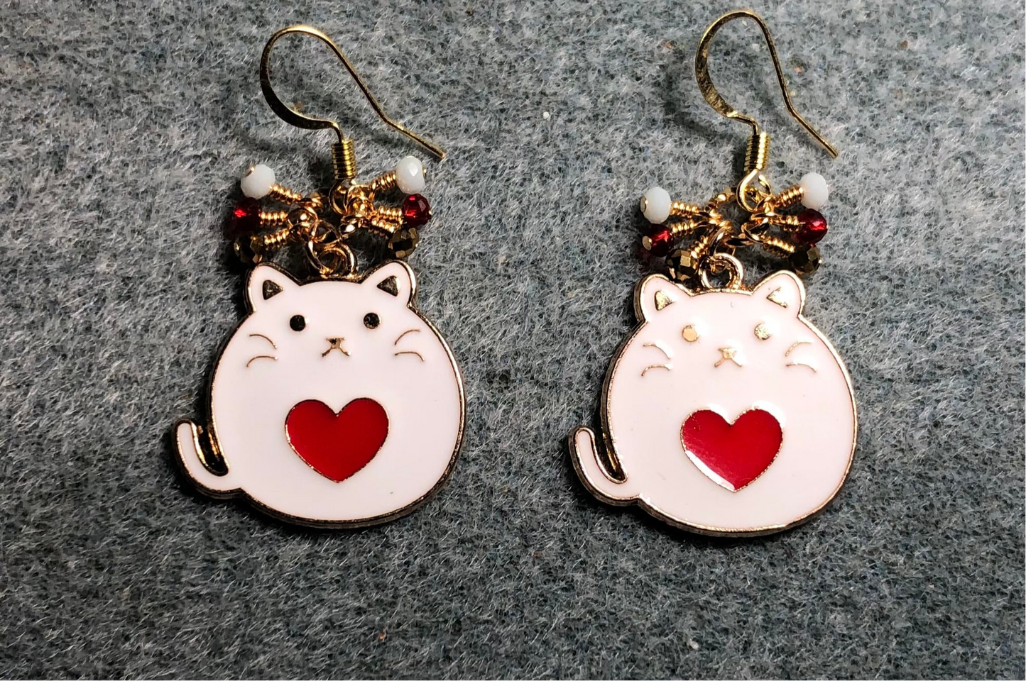 White and red enamel fat cat charm earrings adorned with tiny dangling red, white, and gold Chinese crystal beads.