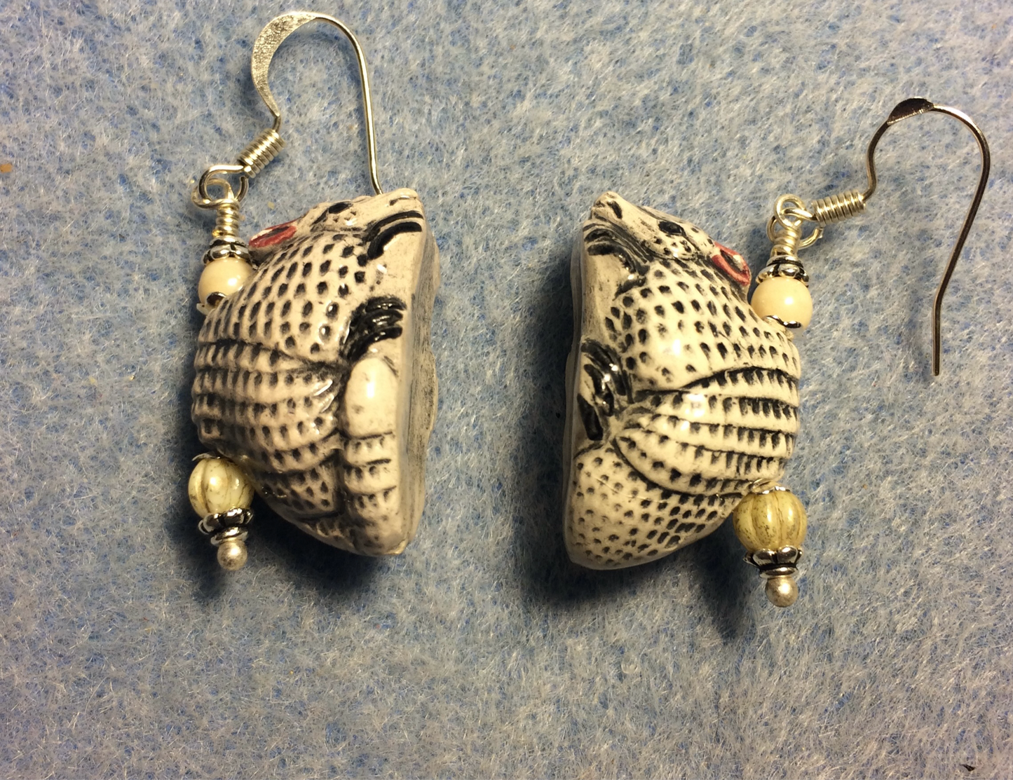 Tan and white ceramic armadillo bead earrings adorned with off white Czech glass beads.
