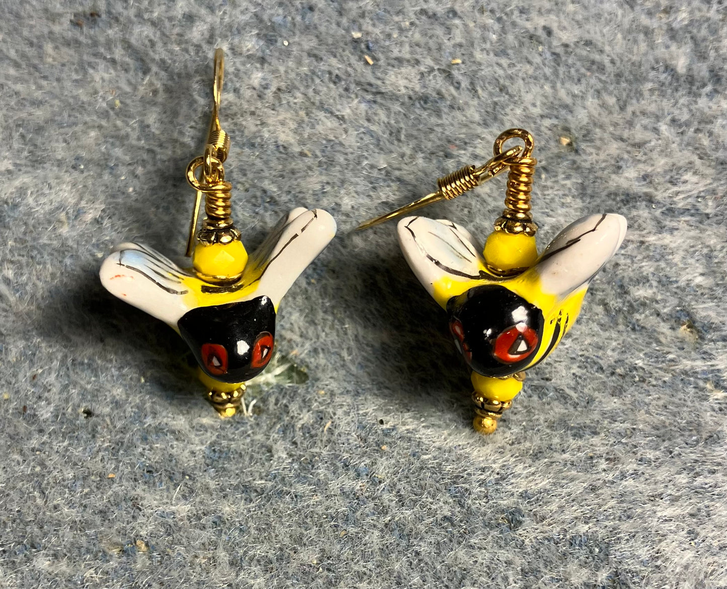 Yellow, black, white, and red ceramic honeybee bead earrings adorned with yellow Chinese crystal beads.
