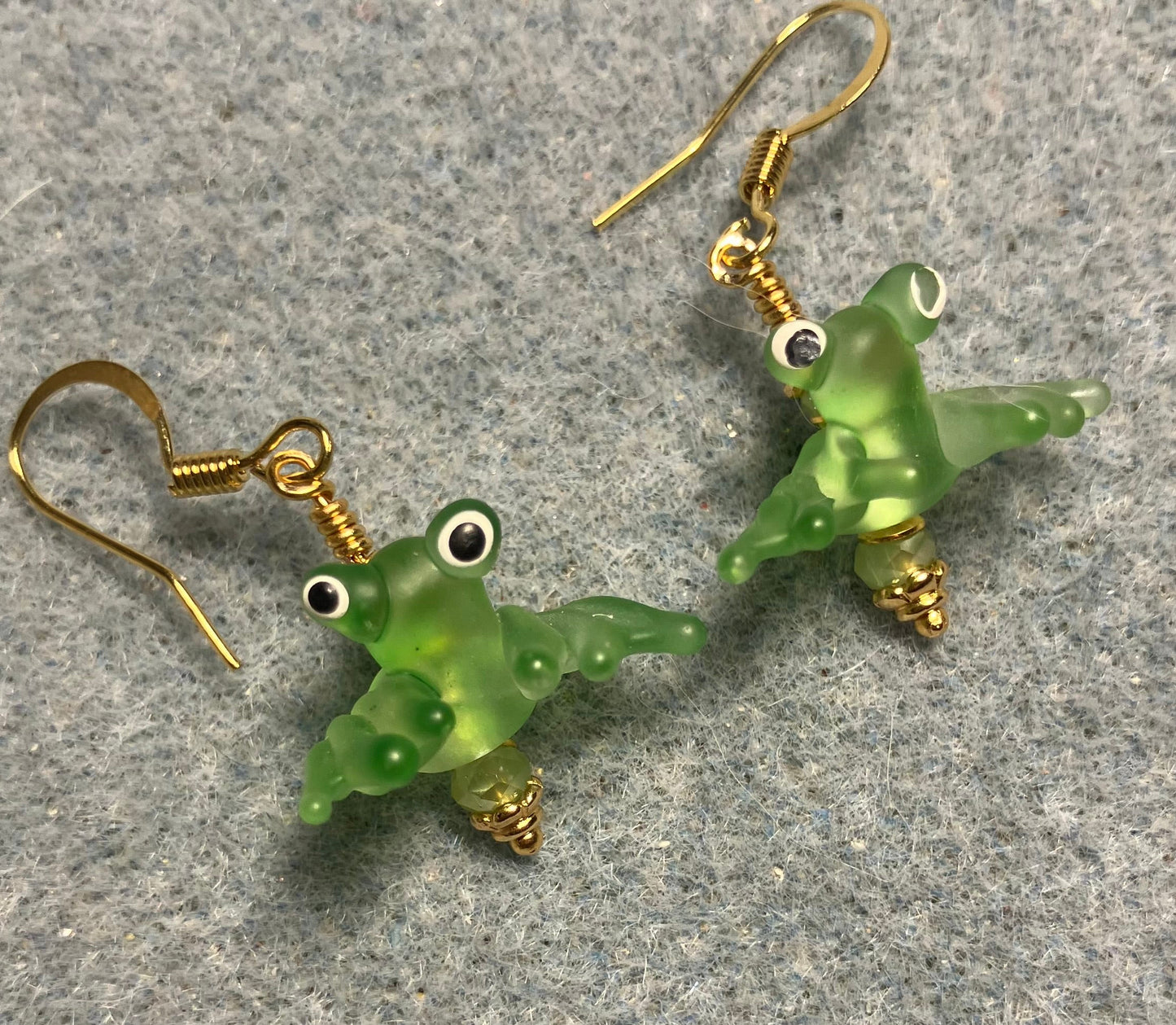 Tiny olive green lamp work frog bead earrings adorned with tiny olive green Chinese crystal beads.