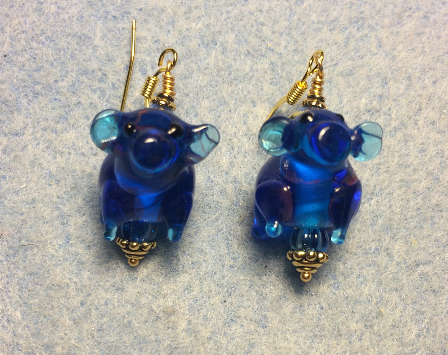 Translucent blue lamp work pig bead earrings adorned with blue Czech glass beads.