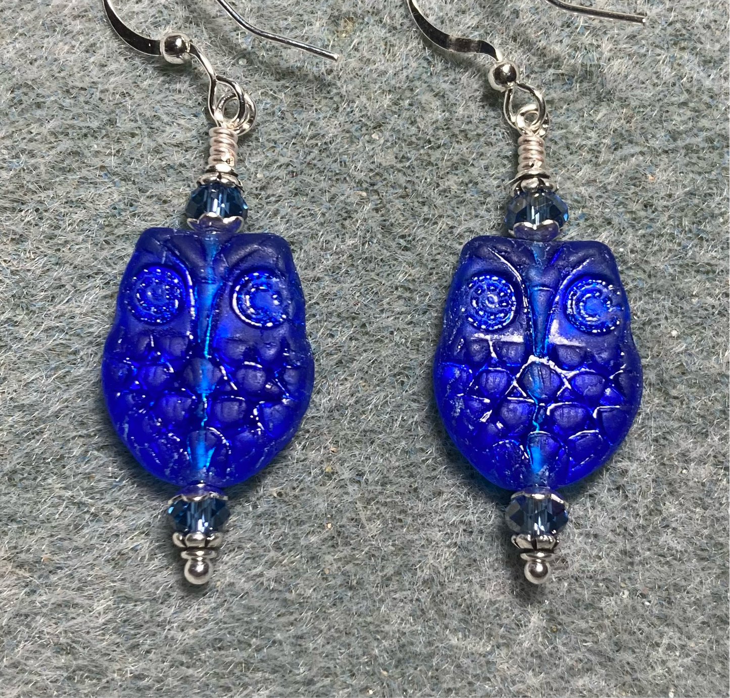 Metallic blue Czech glass owl bead earrings adorned with blue Chinese crystal beads.