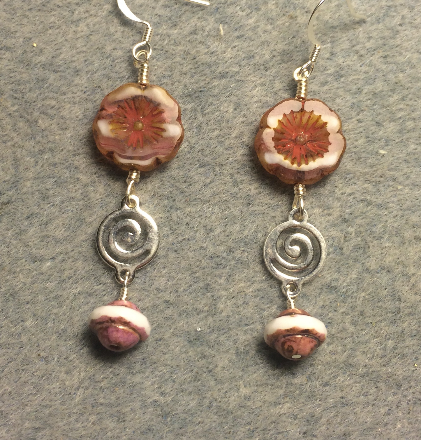 Pink and white Czech glass pansy bead earrings adorned with silver swirly connectors and pink Czech glass Saturn beads.