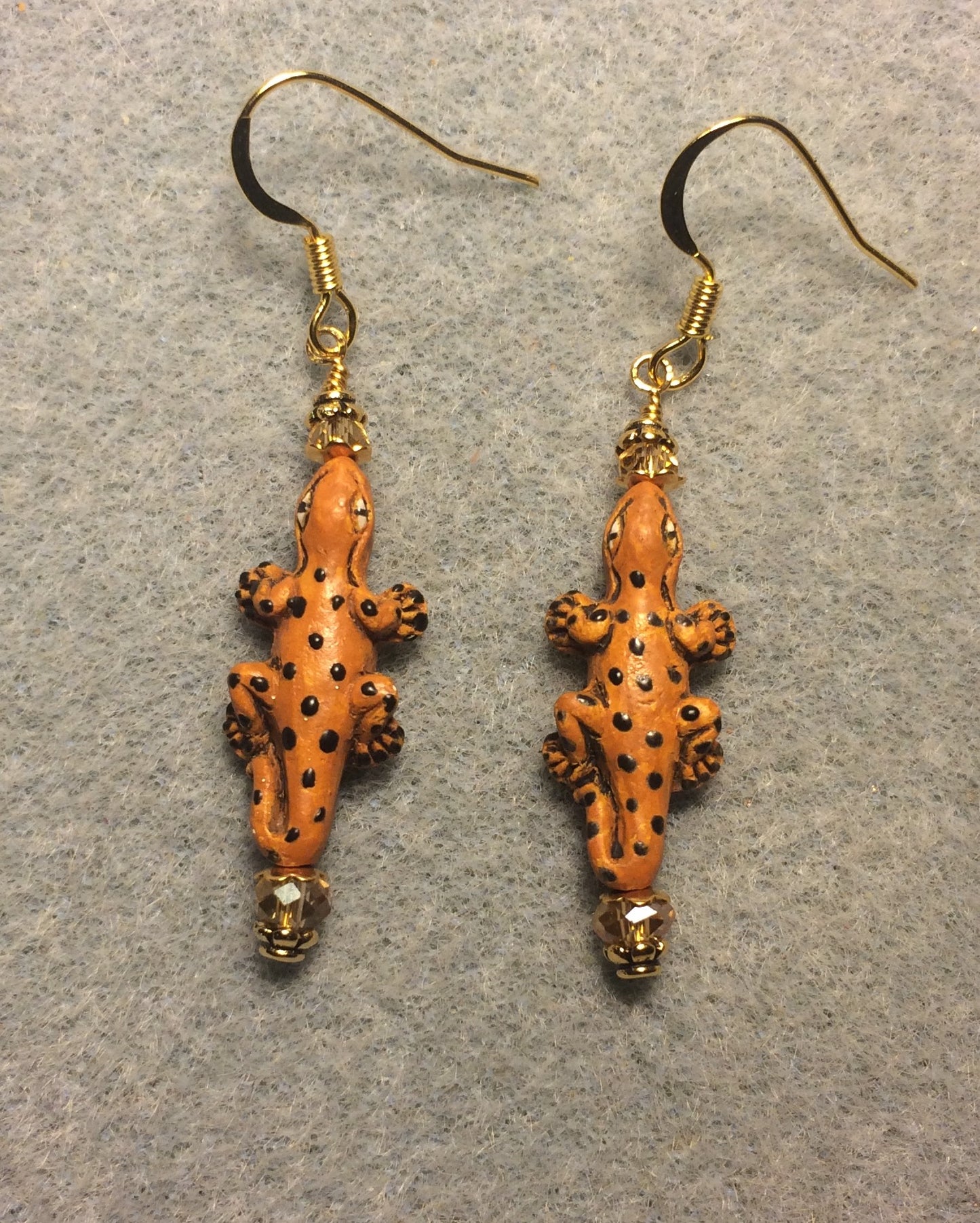 Small orange and black ceramic spotted lizard bead earrings adorned with amber Chinese crystal beads.