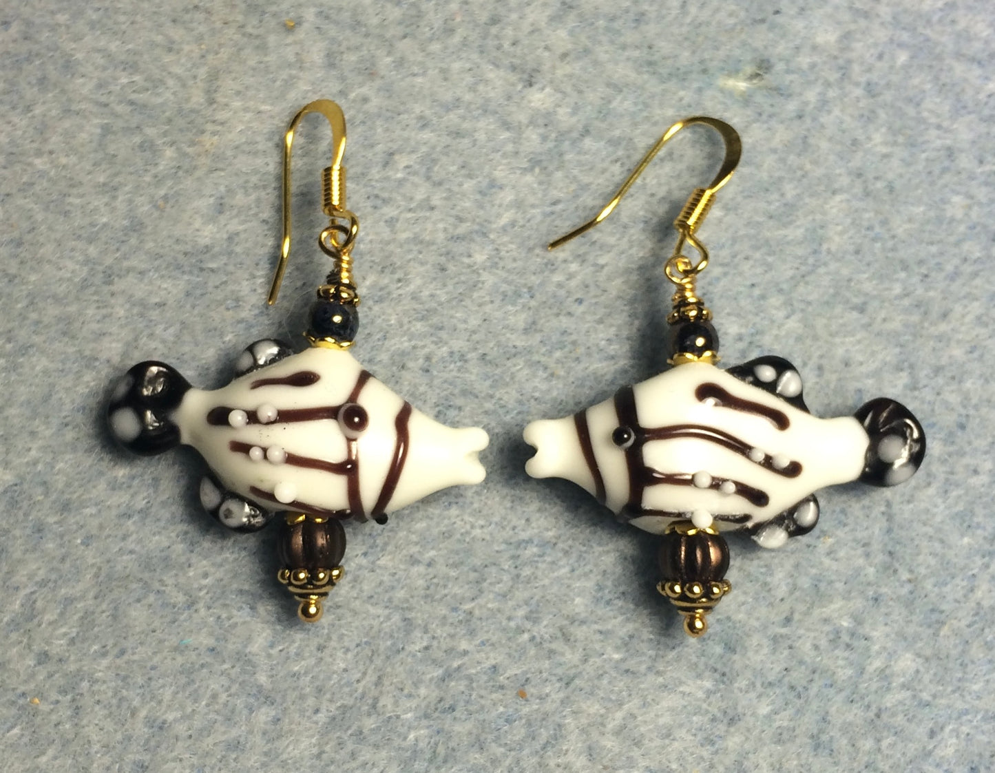 Brown and white lamp work striped kissing fish bead earrings adorned with brown Czech glass beads.