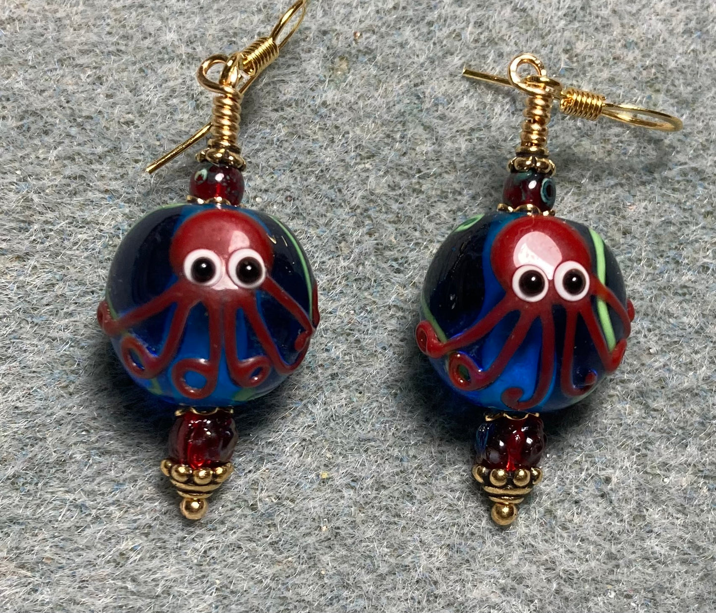 Blue and dark red lamp work octopus bead earrings adorned with dark red Czech glass beads.