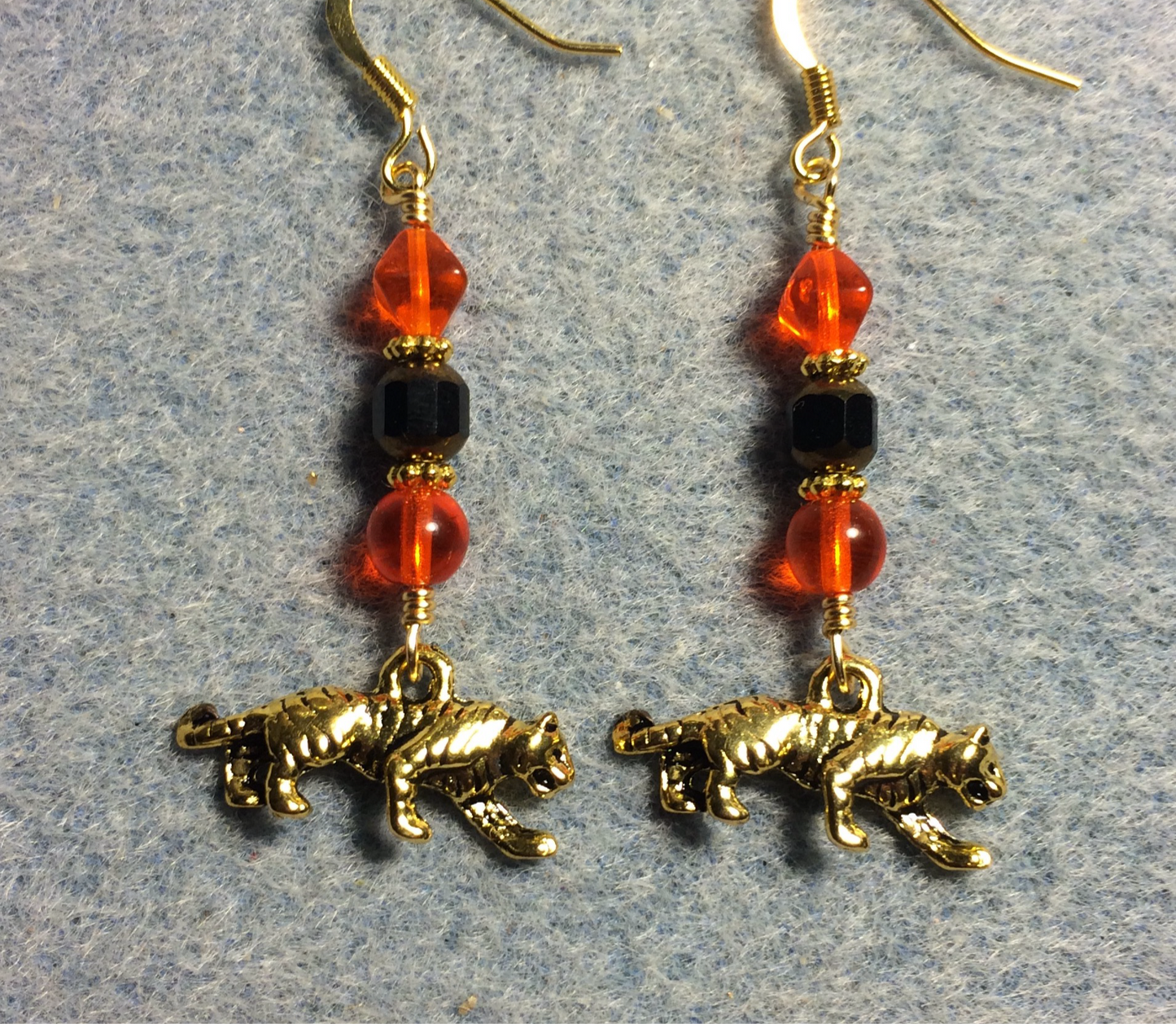 Gold tiger charm earrings adorned with black and gold Czech glass beads