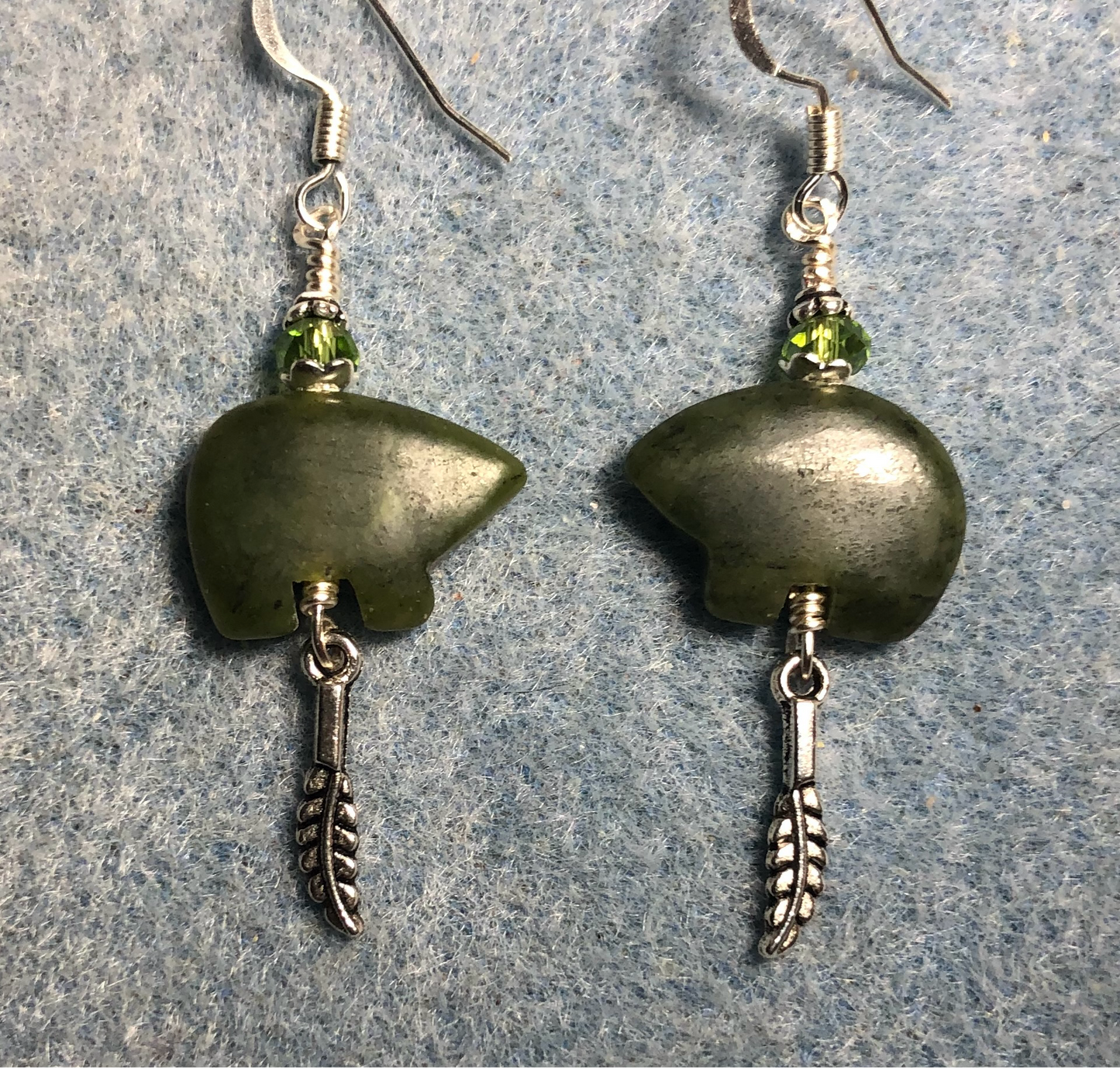 Green jadeite gemstone Zuni bear fetish bear earrings adorned with green crystal beads and tiny silver feather charms.