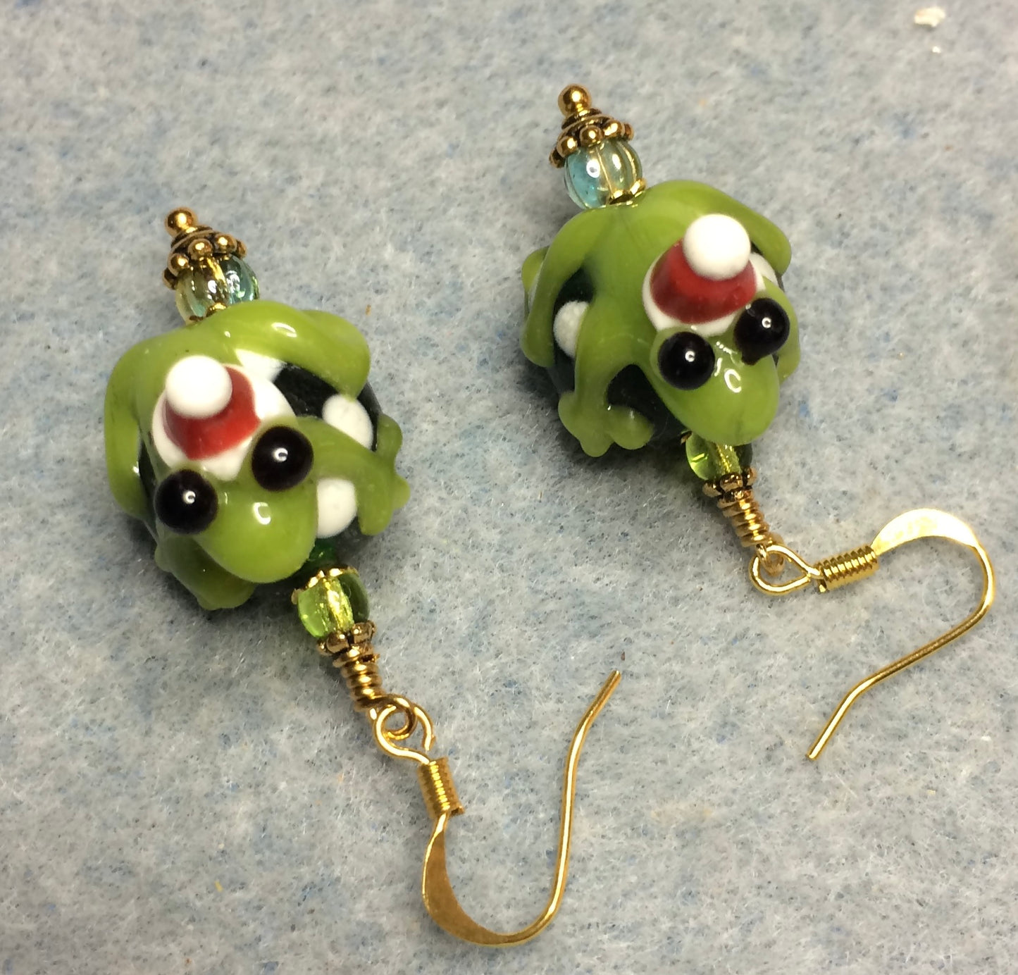 Green lamp work Santa Claus frog bead earrings adorned with green Czech glass beads.