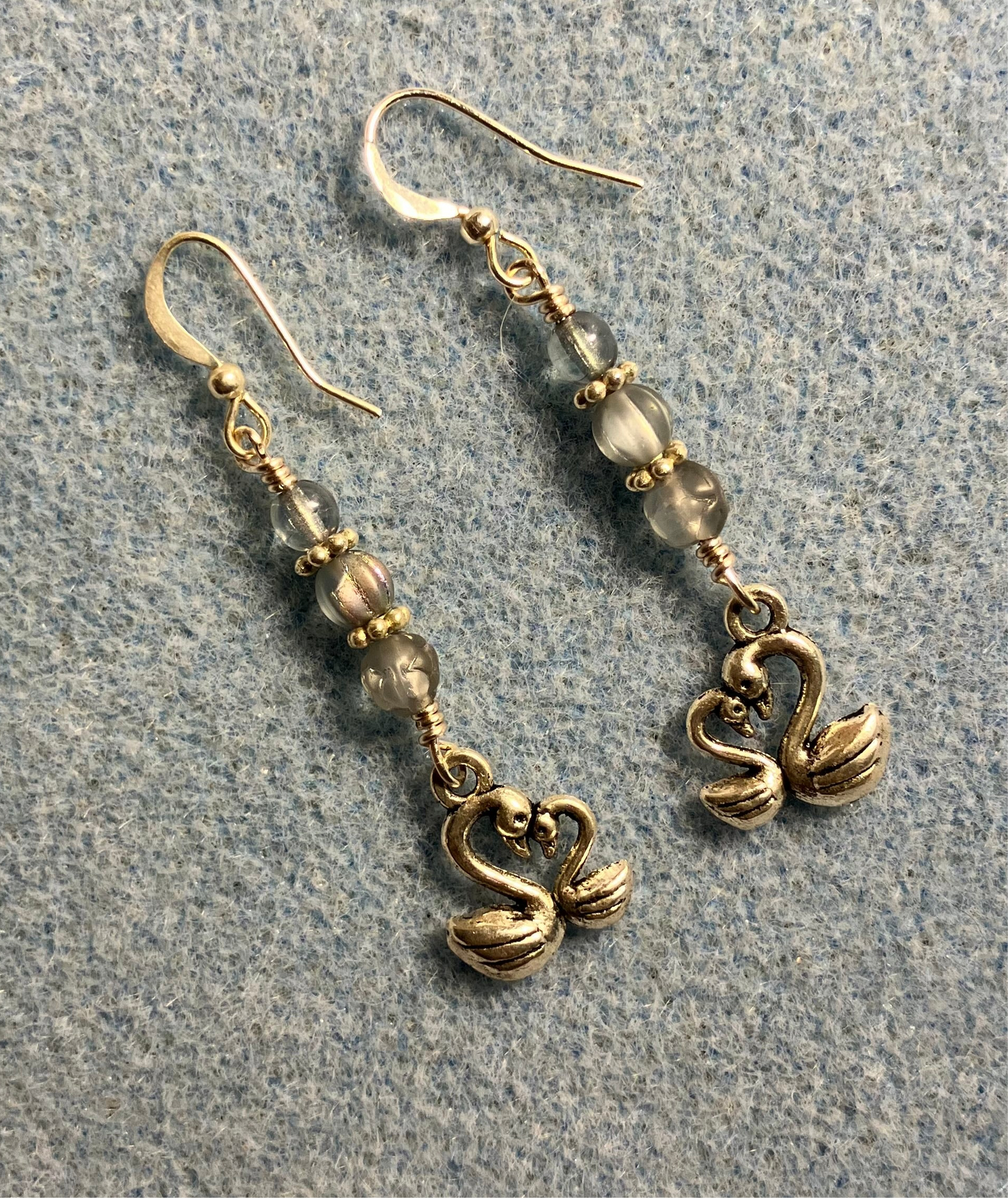 Small silver swan charm earrings adorned with small light blue Czech glass beads