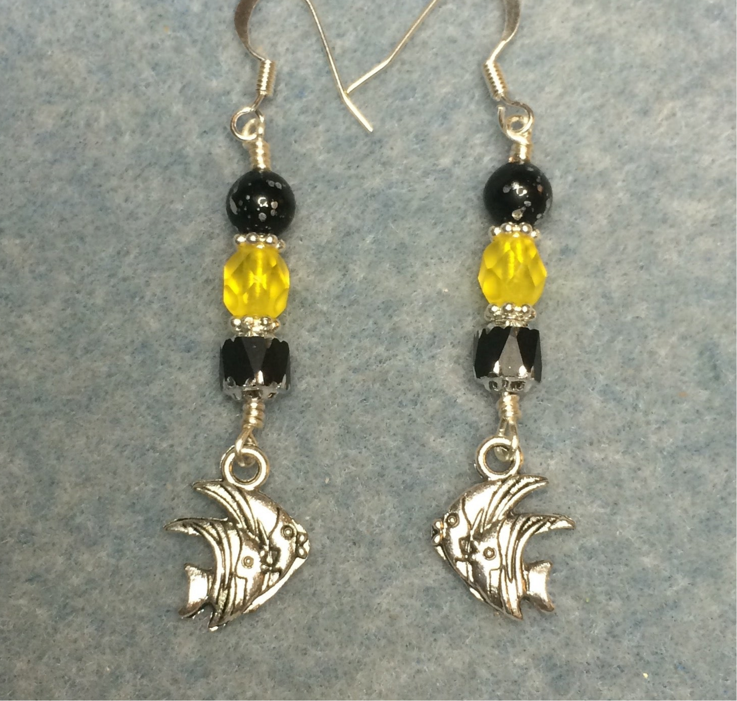 Silver angelfish charm earrings adorned with black and yellow Czech glass beads