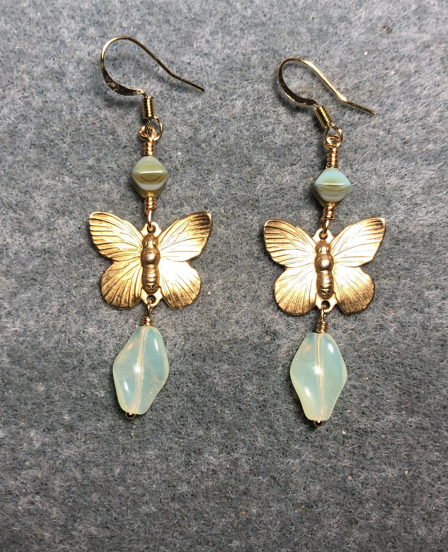 Gold butterfly charm connector earrings adorned with light yellow Czech glass twist beads and yellow Picasso Czech glass beads.