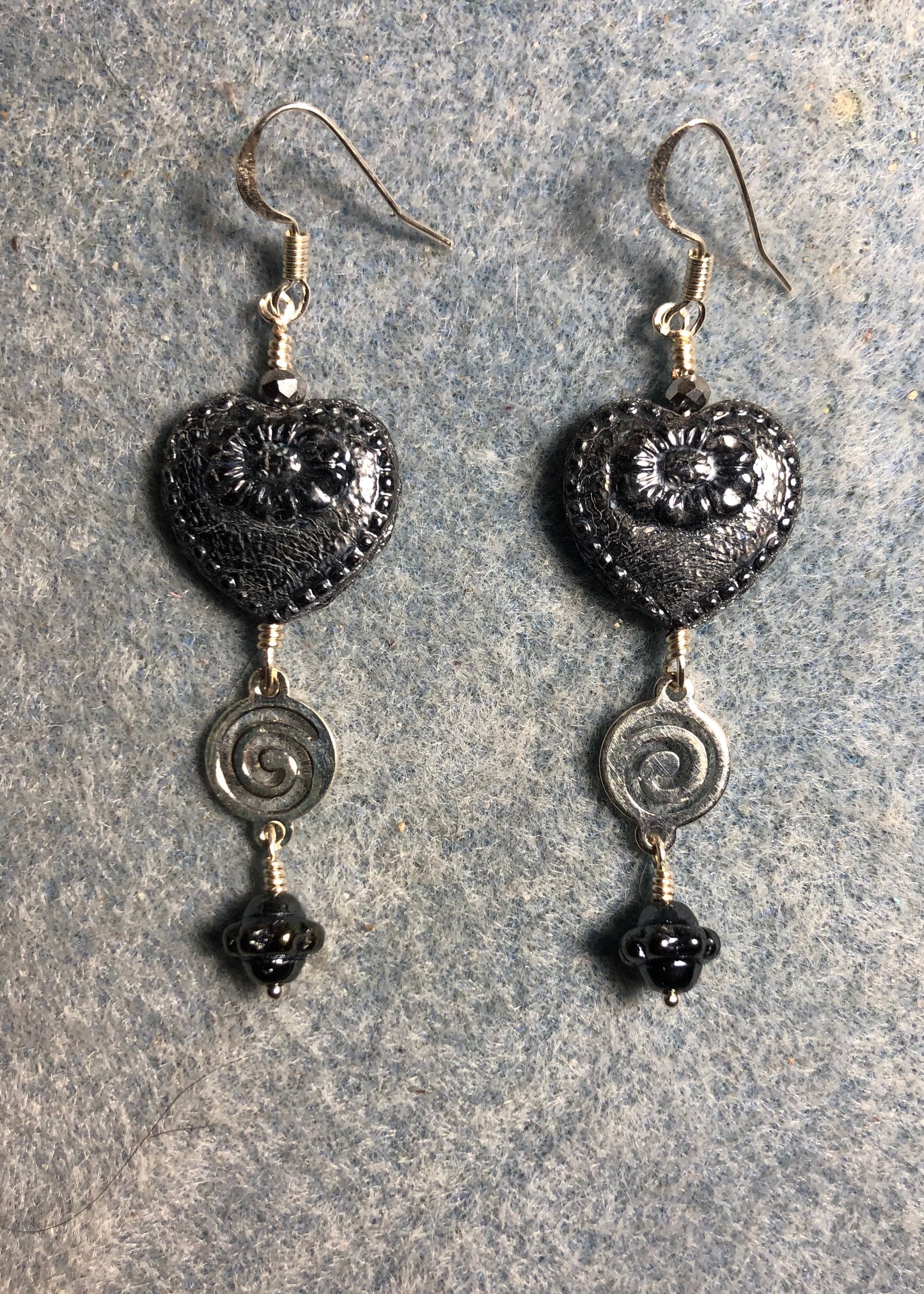 Silver black Czech glass heart bead earrings adorned with silver swirly links and silver black Czech glass Saturn beads.