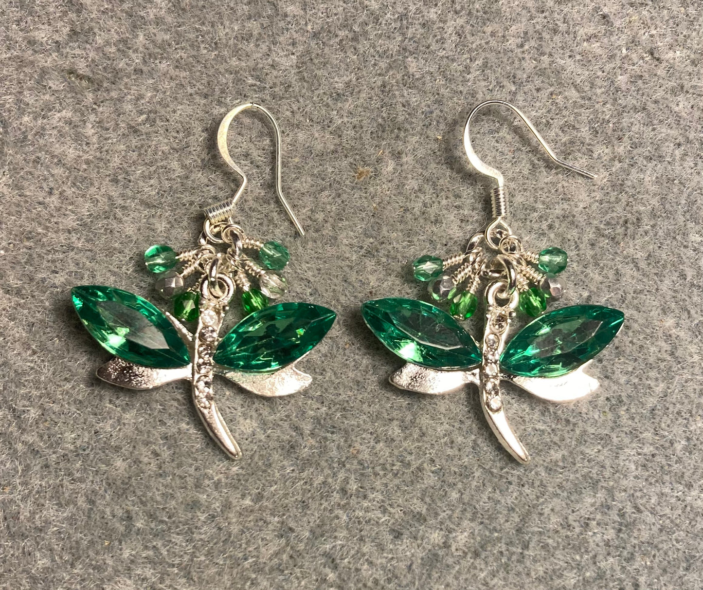 Green and silver rhinestone dragonfly charm earrings adorned with small dangling green and silver Czech glass beads.