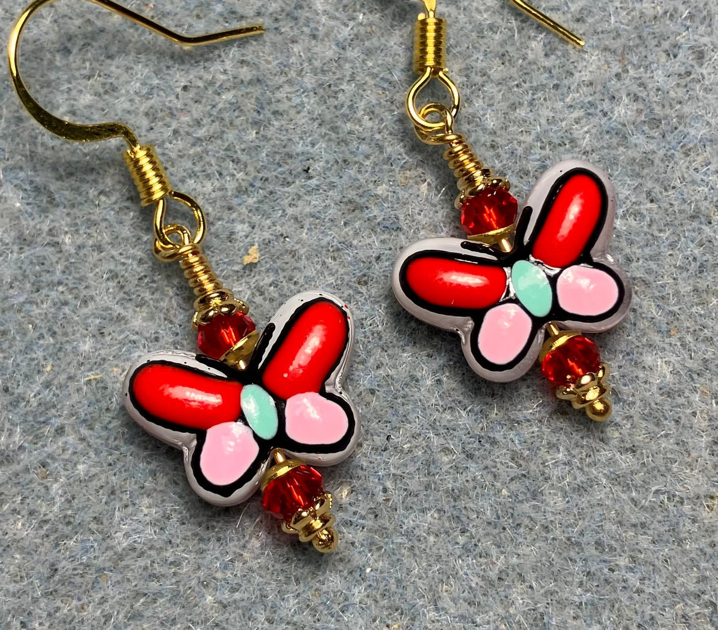 Small red, pink, and aqua ceramic butterfly bead earrings adorned with red Chinese crystal beads.