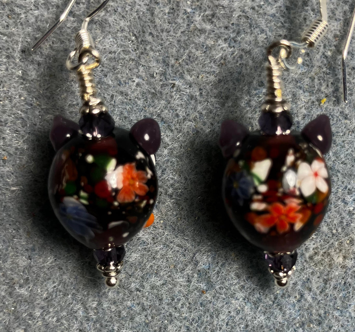Purple, orange, and red lamp work owl bead earrings adorned with purple Chinese crystal beads.