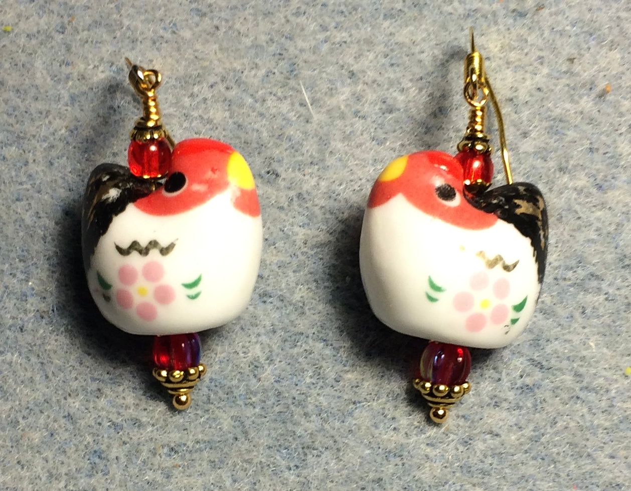 White, black, and red ceramic chicken bead earrings adorned with red Czech glass beads.