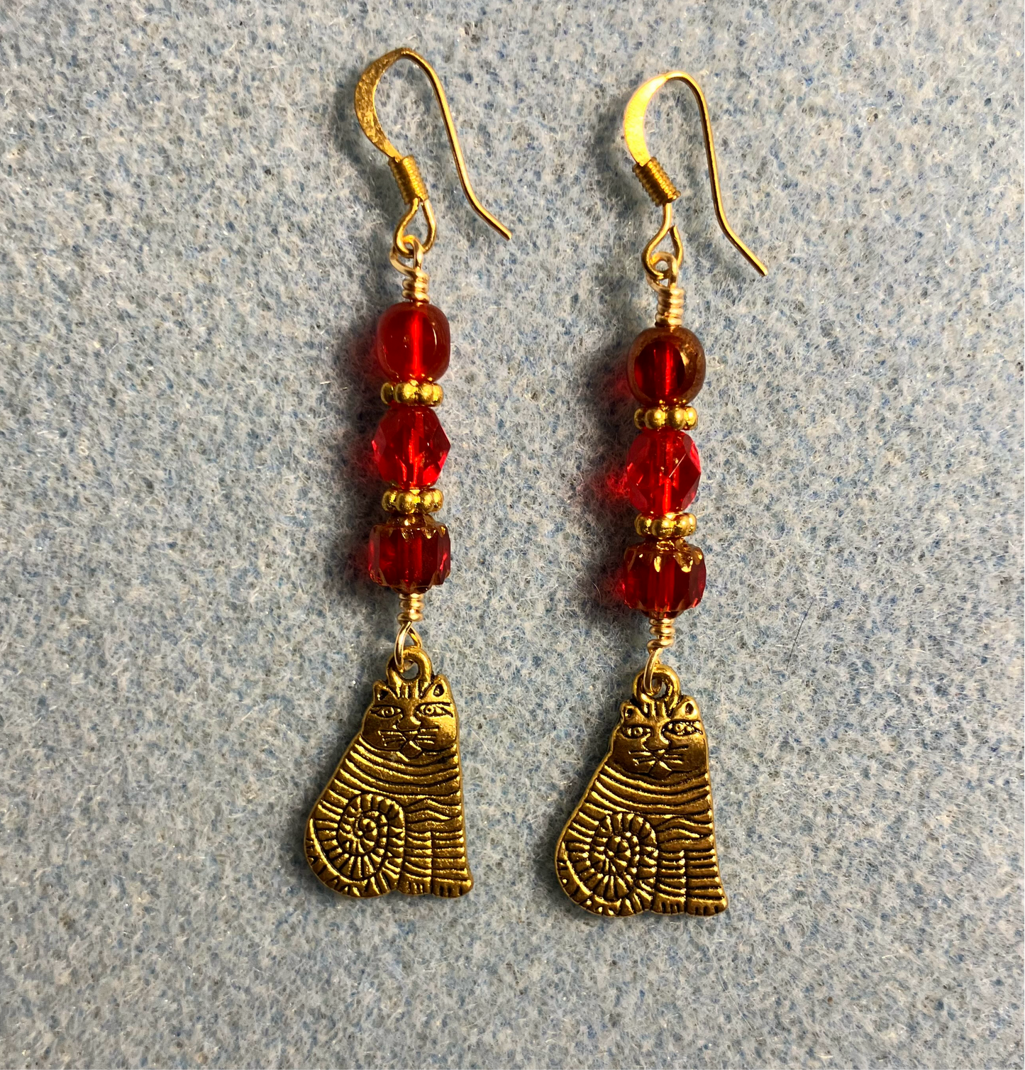 Gold sitting cat charm earrings adorned with red Czech glass beads