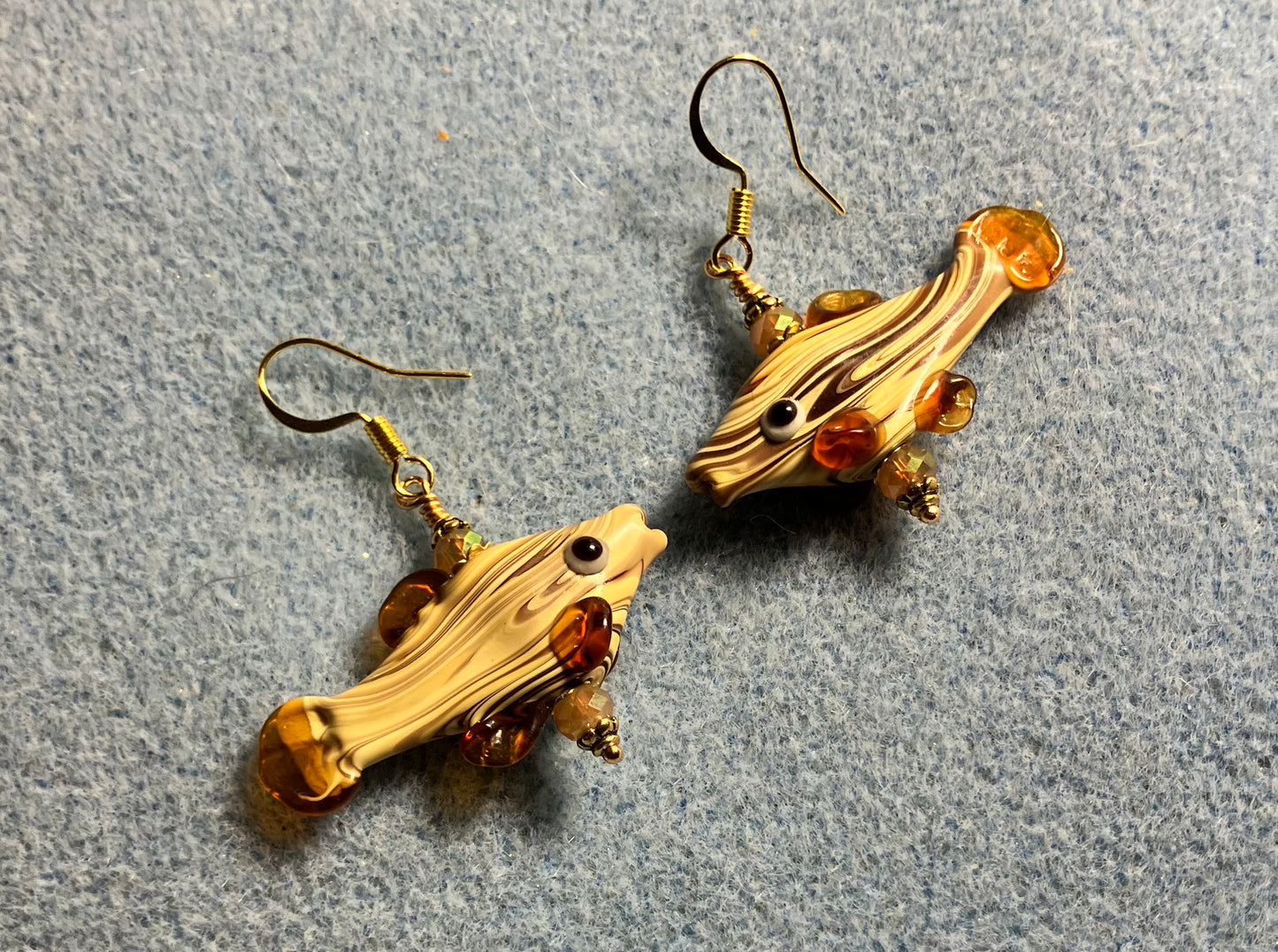 Tan lamp work striped fish bead earrings adorned with tan Chinese crystal beads.