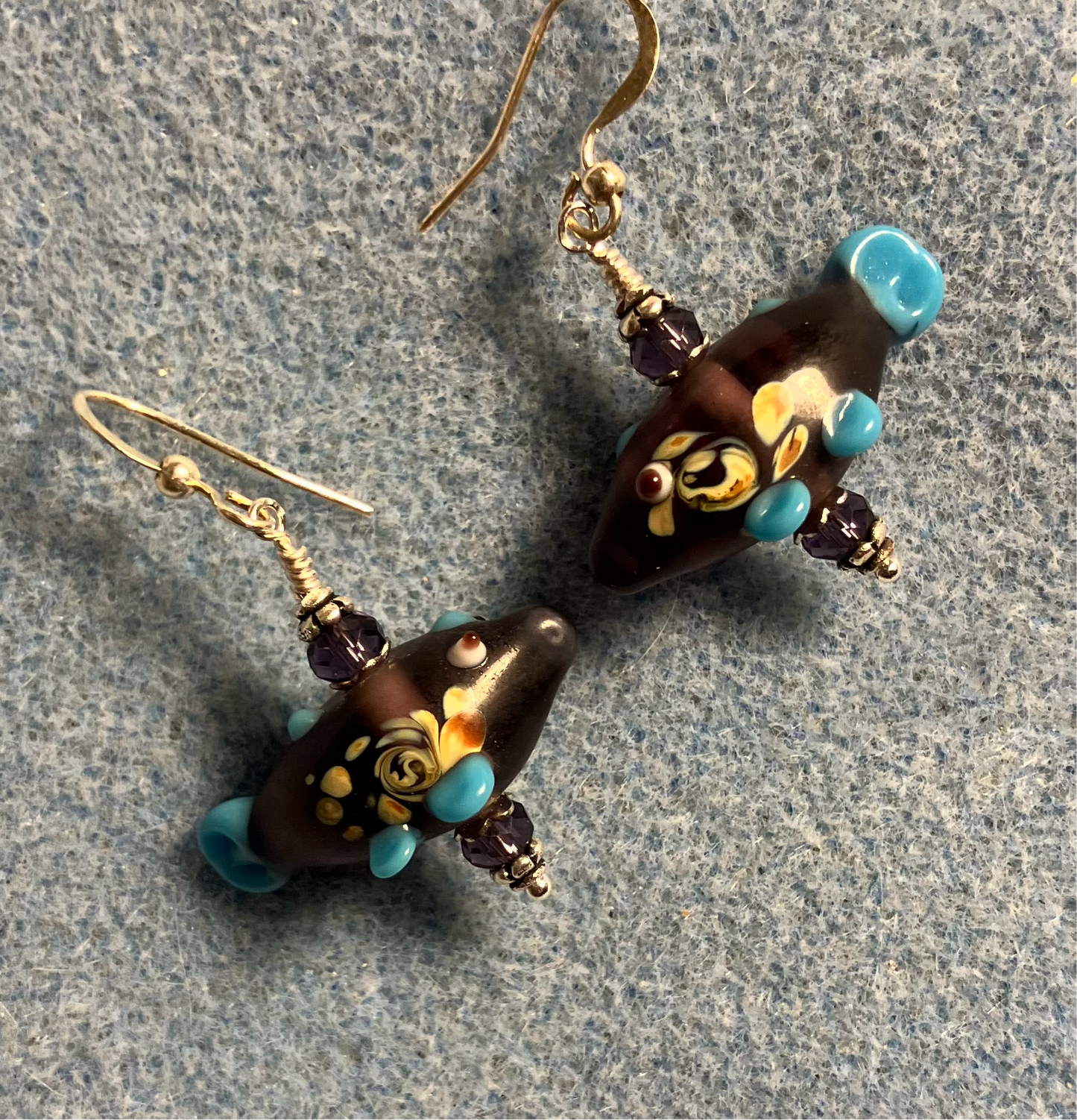Purple lamp work fish bead earrings adorned with purple Chinese crystal beads.