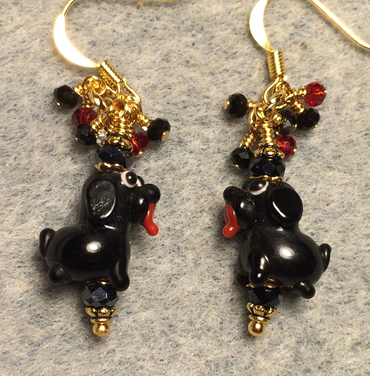 Tiny black lamp work puppy dog bead earrings adorned with black Chinese crystal beads and tiny dangling red and black Chinese crystal beads.