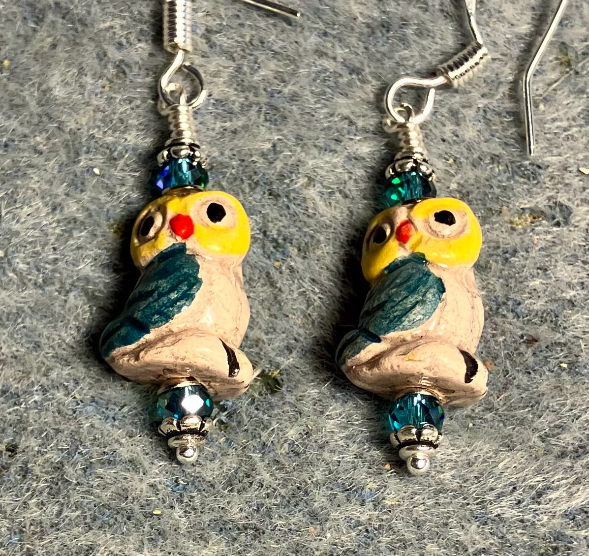 Small teal and yellow ceramic owl bead earrings adorned with teal Chinese crystal beads.