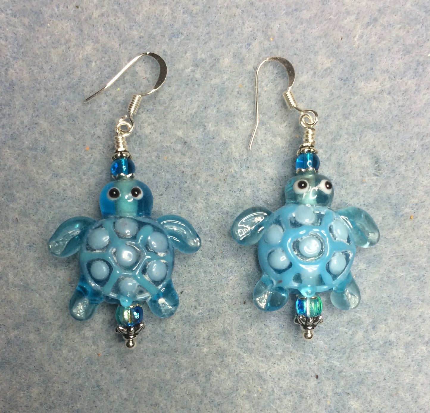 Turquoise lamp work spotted turtle bead earrings adorned with turquoise Czech glass beads.