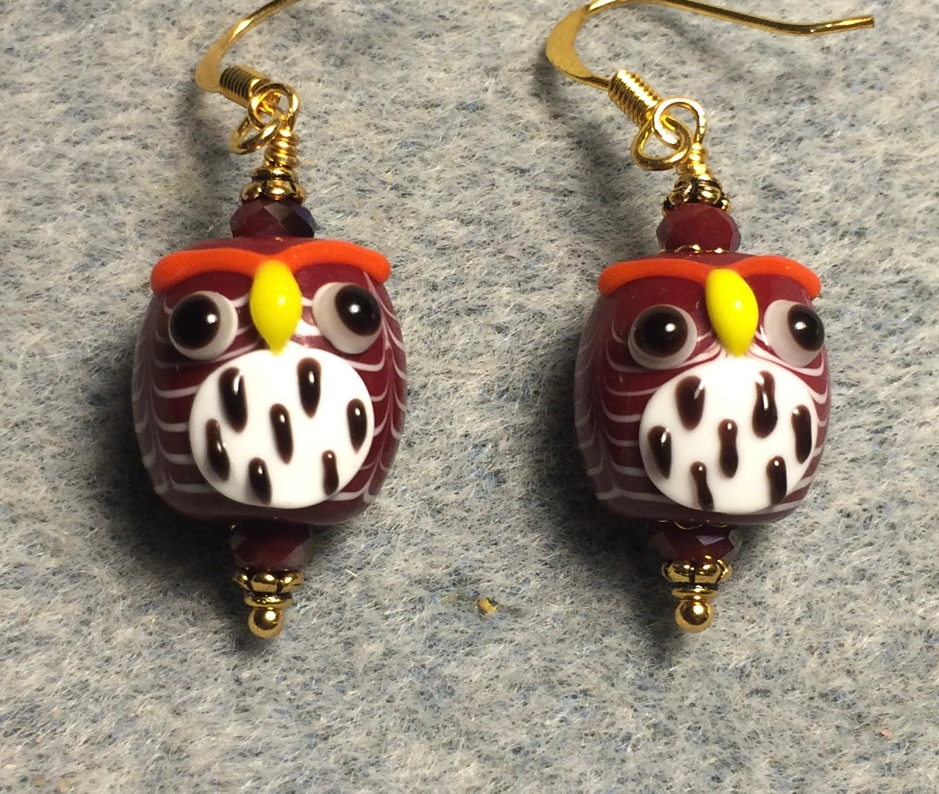 Dark red and white lamp work spotted owl bead earrings adorned with dark red Chinese crystal beads.