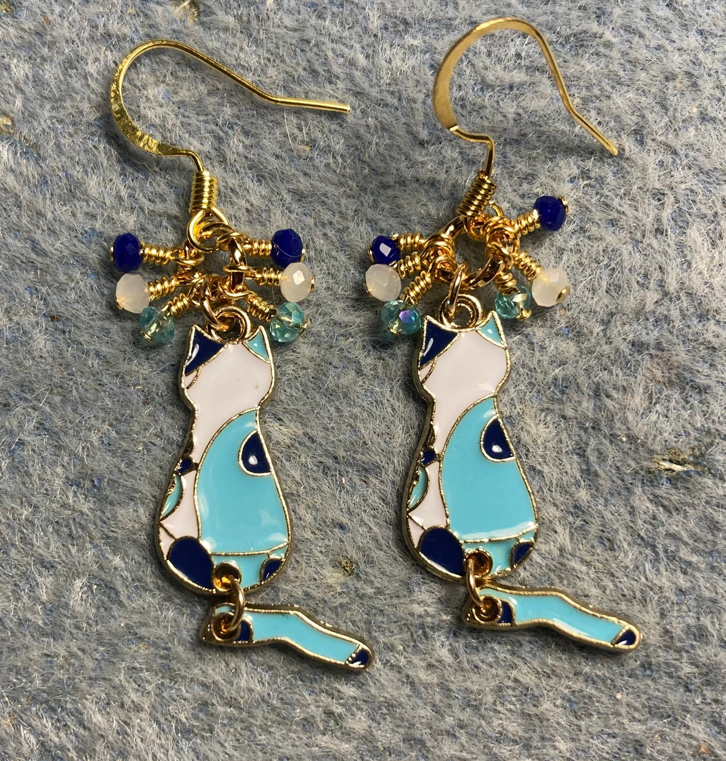Turquoise, dark blue, and white enamel cat charm earrings adorned with tiny dangling turquoise, dark blue, and white Chinese crystal beads.
