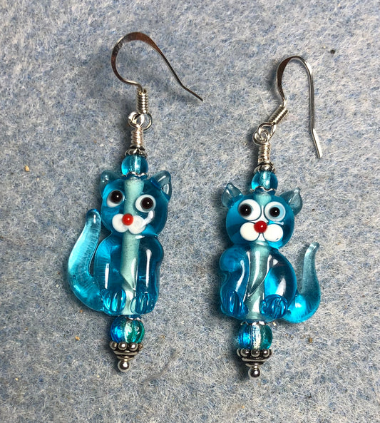 Translucent turquoise lamp work cat bead earrings adorned with turquoise Czech glass beads.