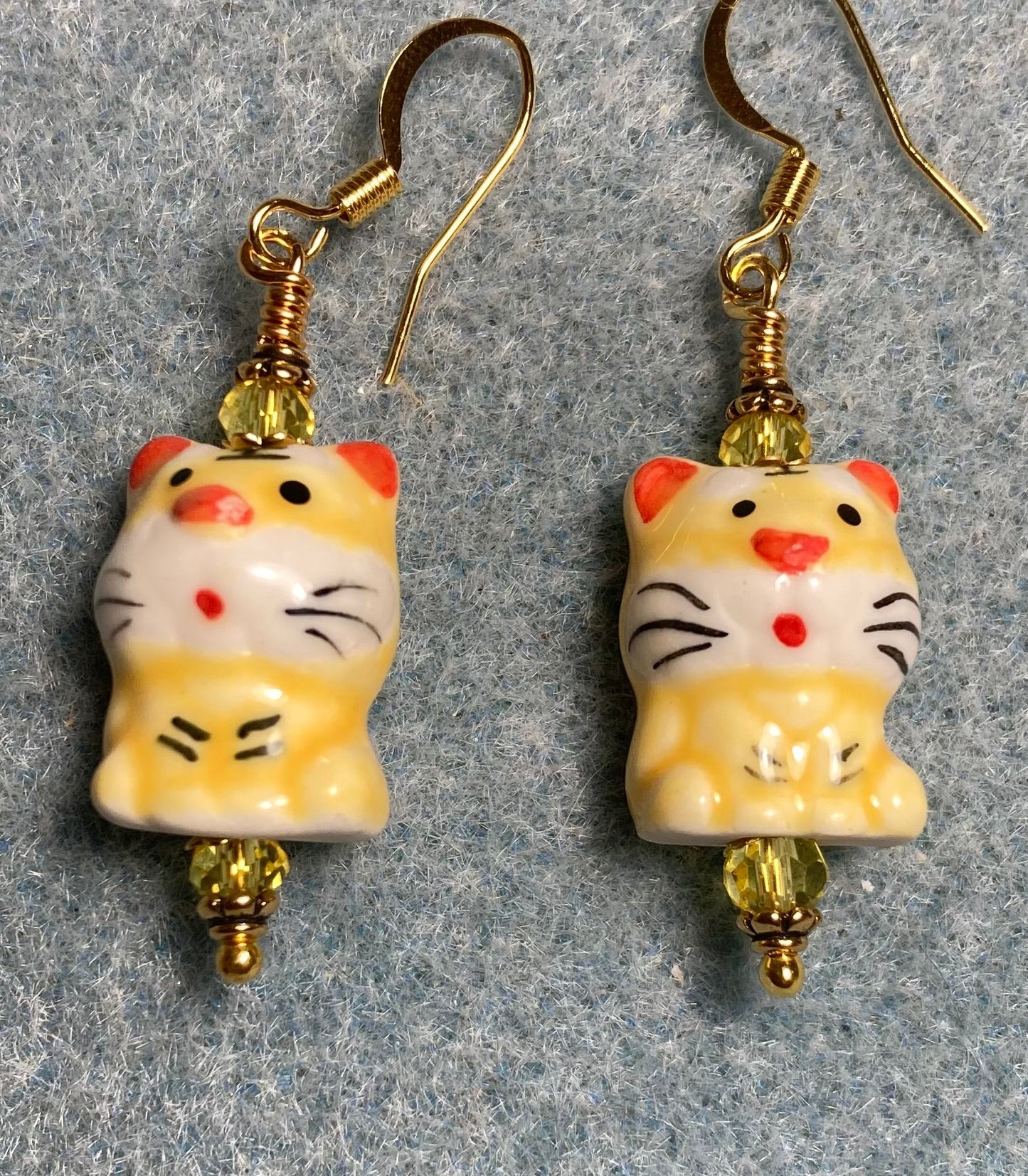 Yellow, black, and red ceramic tiger bead earrings adorned with yellow Chinese crystal beads.