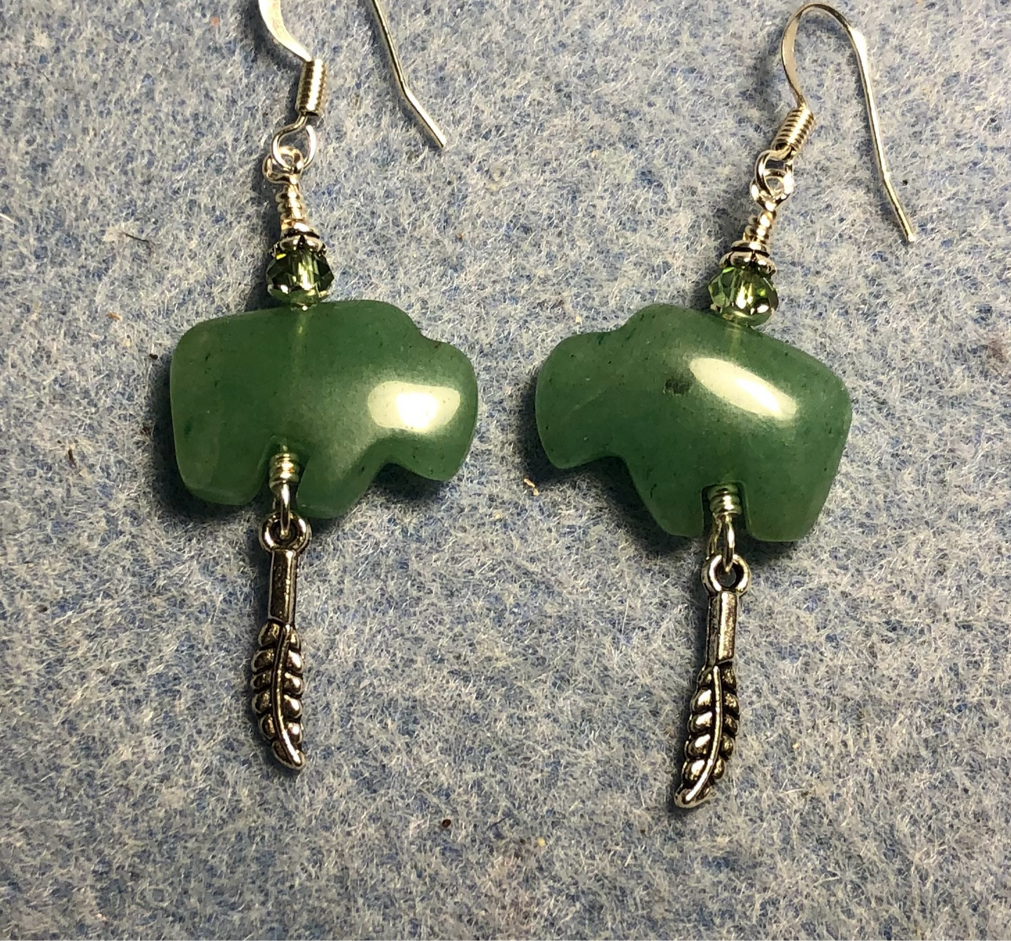 Green aventurine gemstone buffalo fetish bead earrings adorned with sparkly green crystal beads and tiny silver feather charms.
