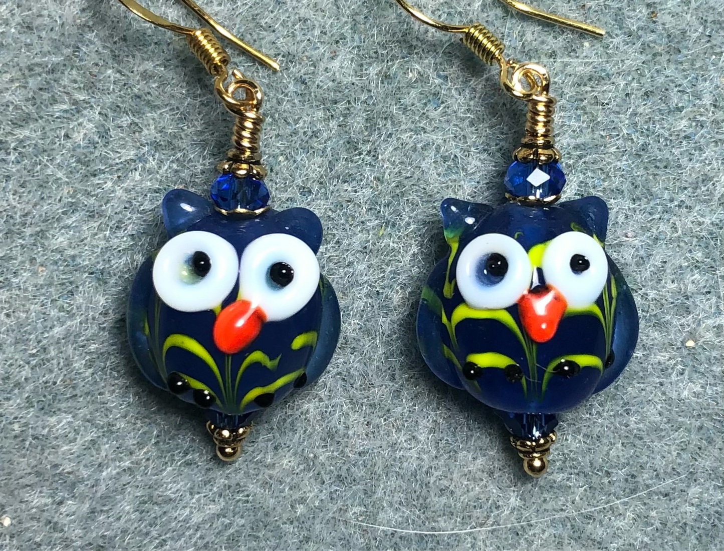 Bright blue lamp work owl bead earrings adorned with bright blue Chinese crystal beads.