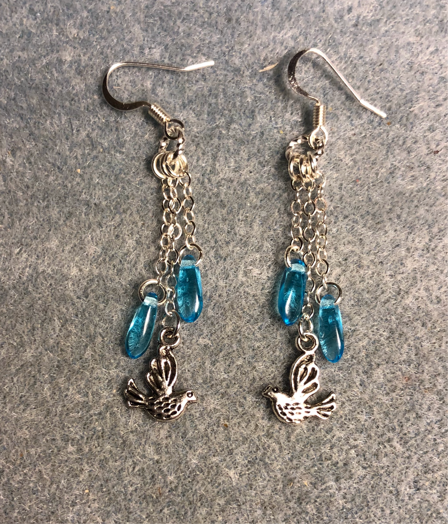 Small silver dove charm earrings attached to silver chain and adorned with small turquoise Czech glass dagger beads