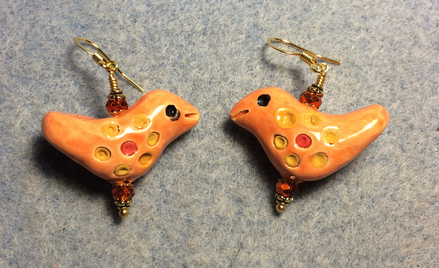 Medium orange, yellow, and red ceramic songbird bead earrings adorned with orange Chinese crystal beads.