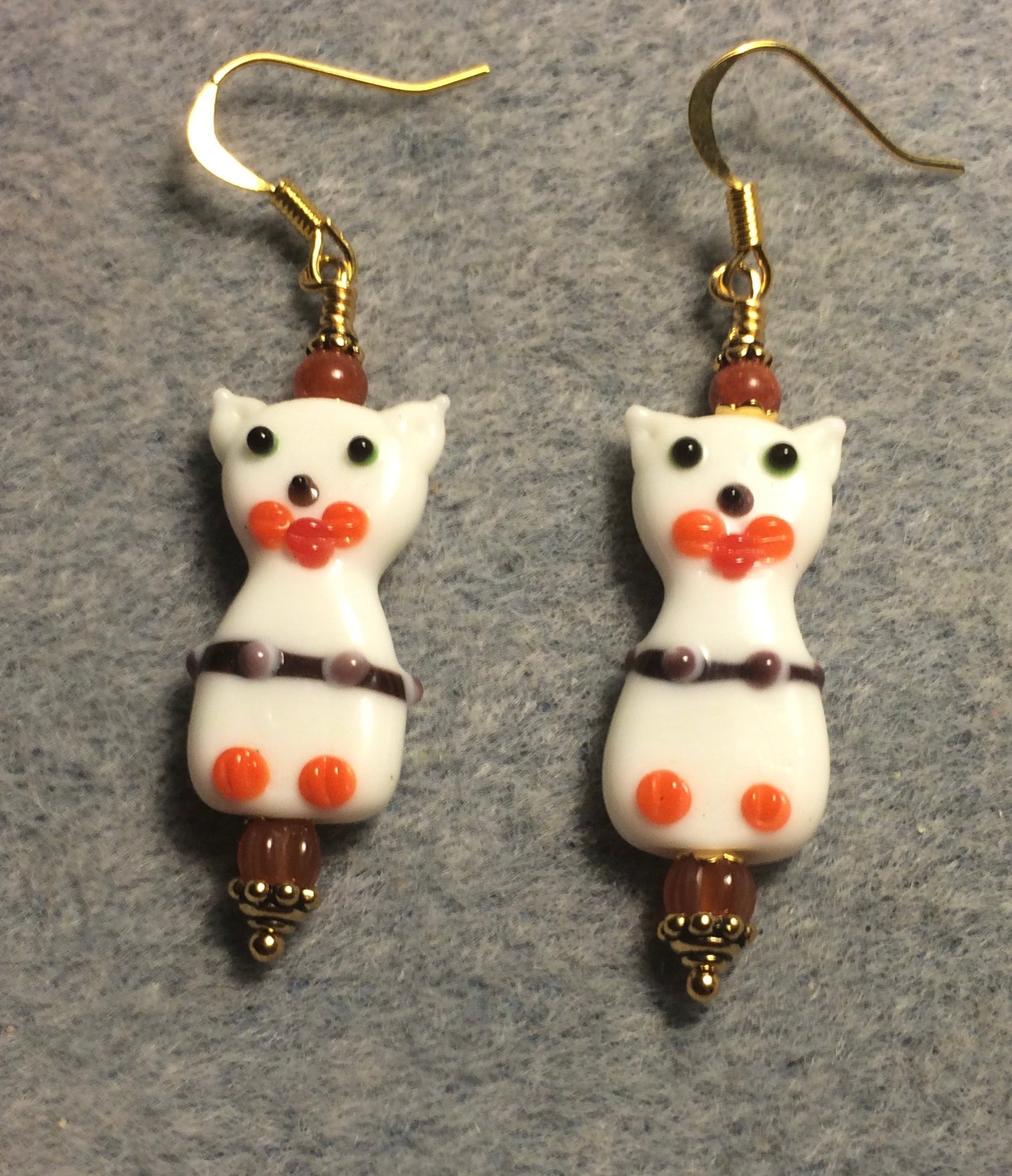 White, orange, and brown lamp work cat bead earrings adorned with orange Czech glass beads.