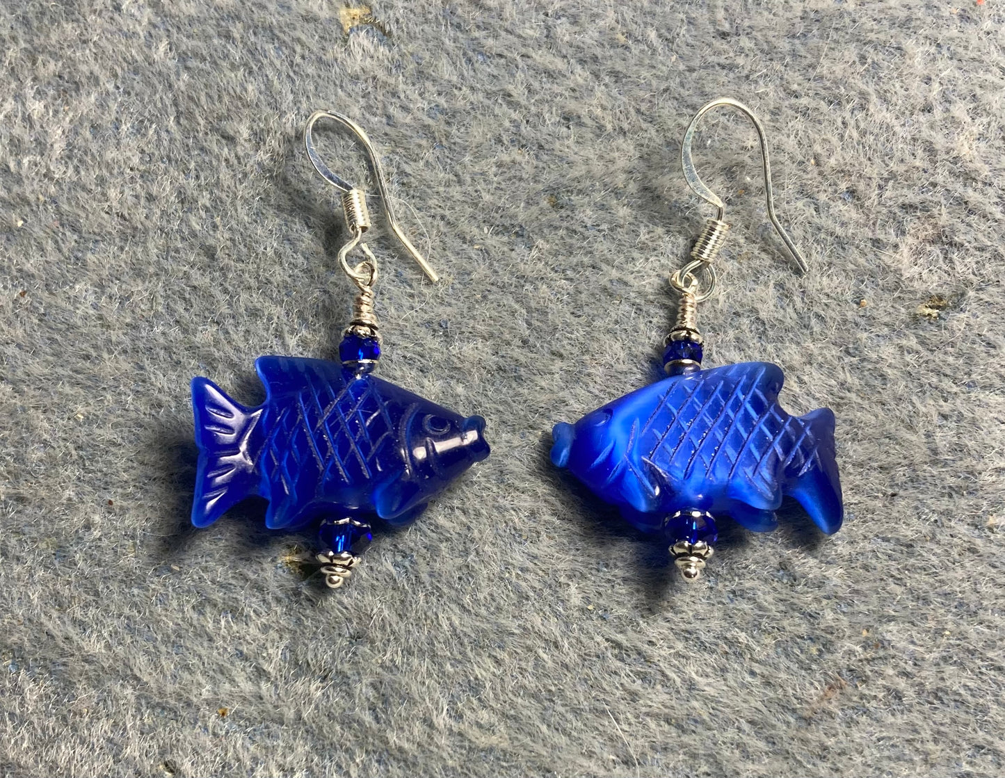 Dark blue fiber optic (cat’s eye) gemstone fish beads and are adorned with dark blue Chinese crystal beads.
