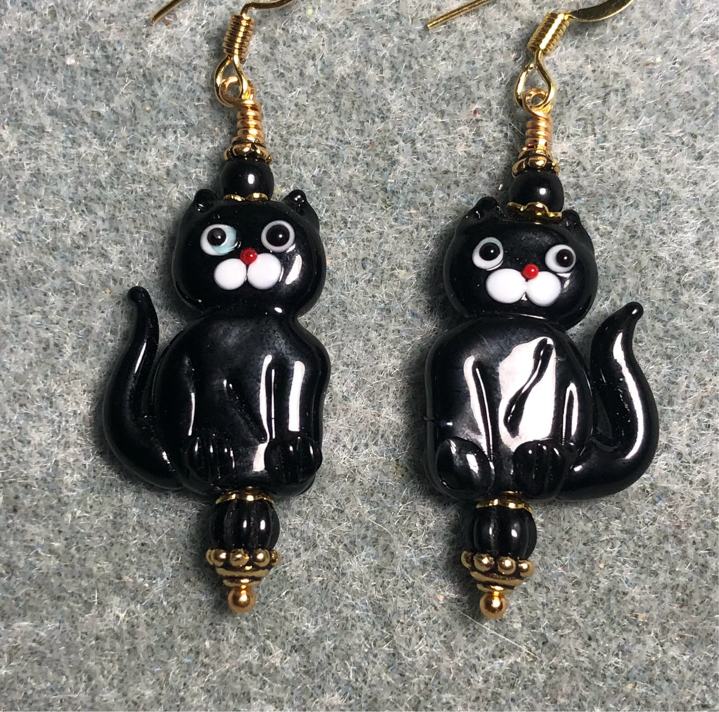 Opaque black lamp work cat bead earrings adorned with black Czech glass beads.