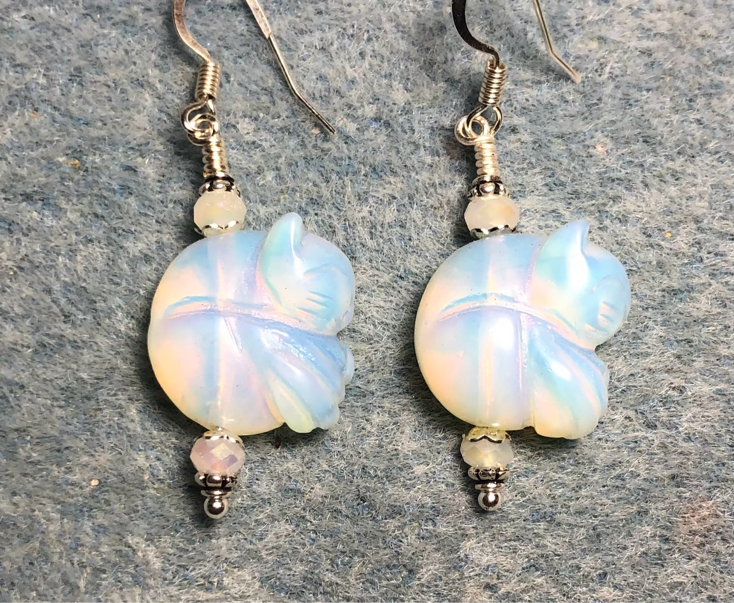 White opalite gemstone sleeping cat bead earrings adorned with white Chinese crystal beads.