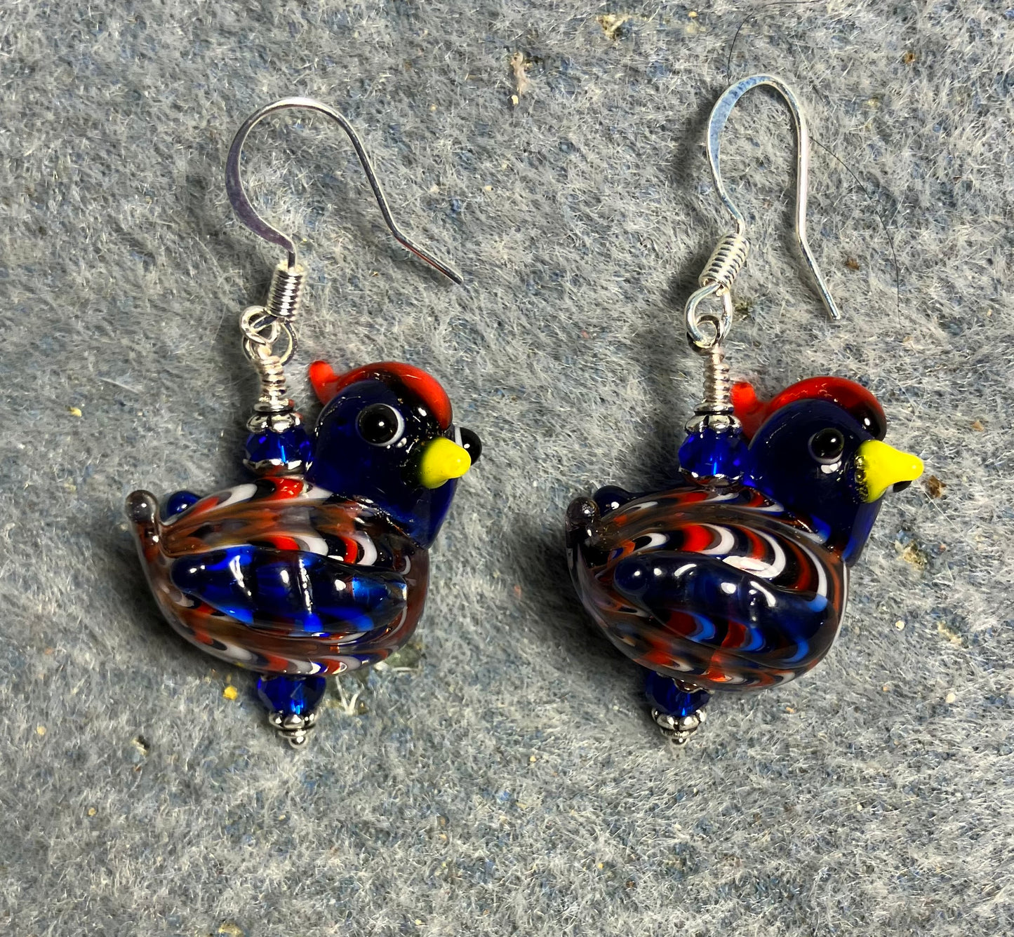 Dark blue, red, and yellow lamp work mottled hen bead earrings adorned with dark blue Chinese crystal beads.