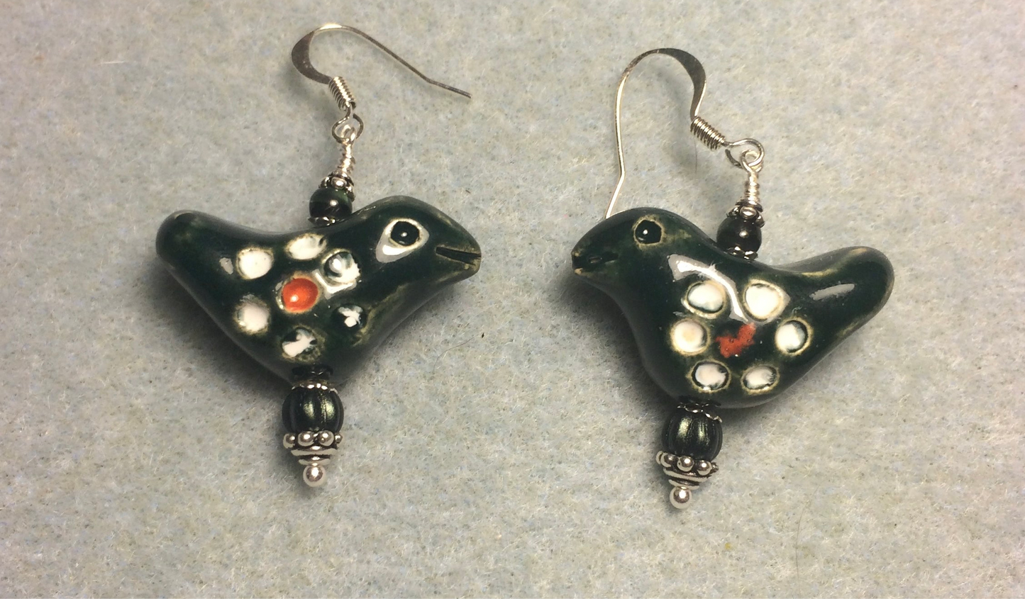 Medium dark green and white ceramic songbird bead earrings adorned with dark green Czech glass beads.