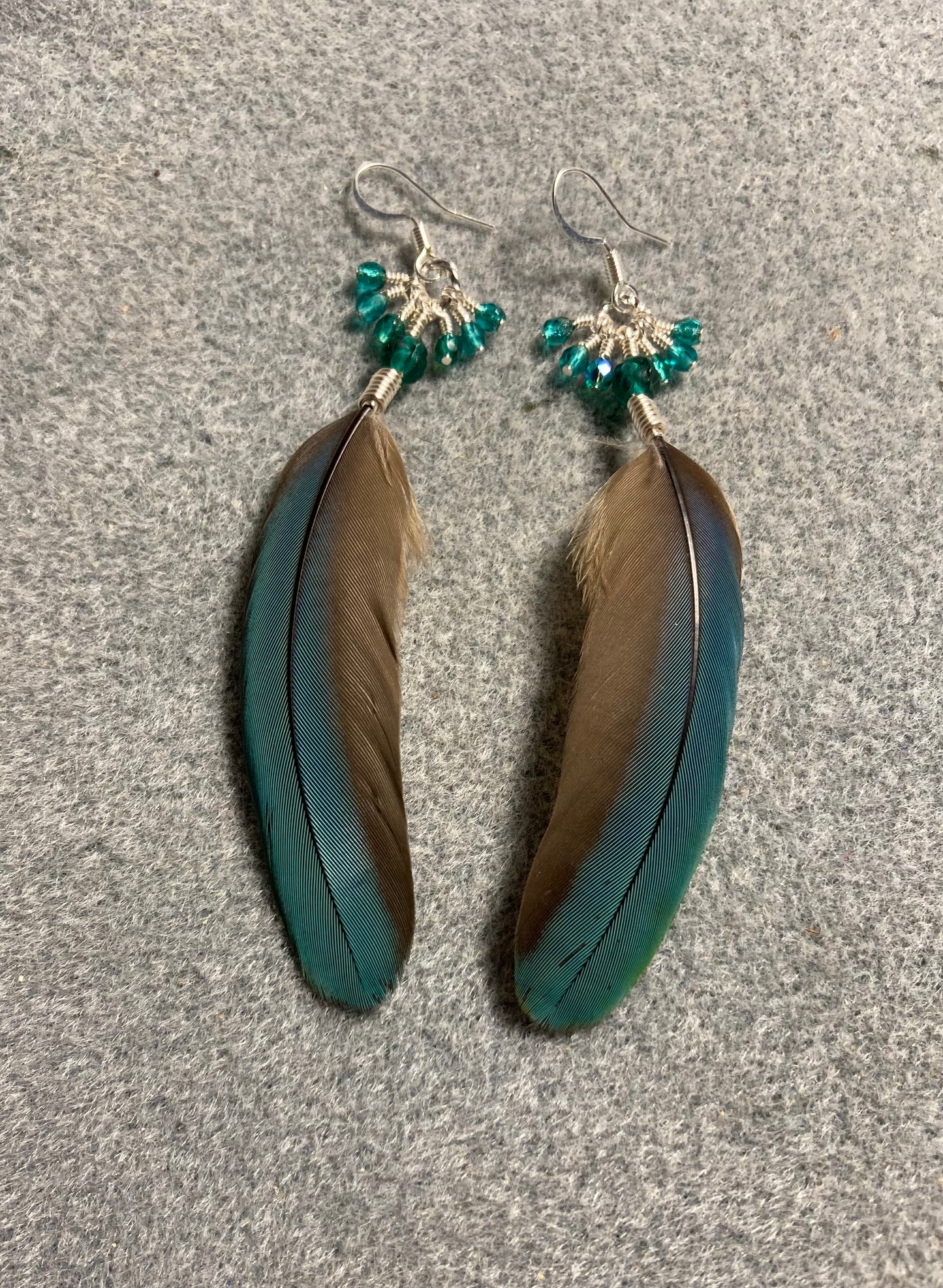 Teal turquoise mini macaw feather earrings adorned with teal Czech glass beads and small dangling teal and turquoise Czech glass beads.