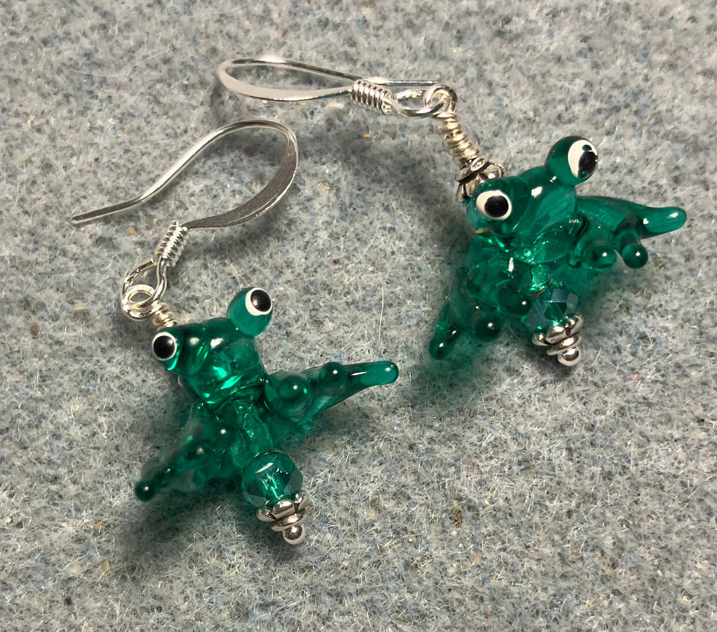 Tiny teal lamp work frog bead earrings adorned with tiny teal Chinese crystal beads.