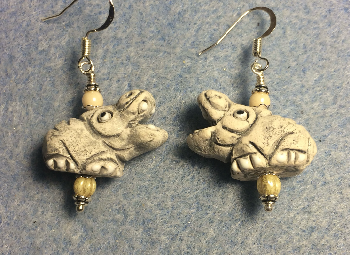 Small beige ceramic crocodile bead earrings adorned with off white Czech glass beads.