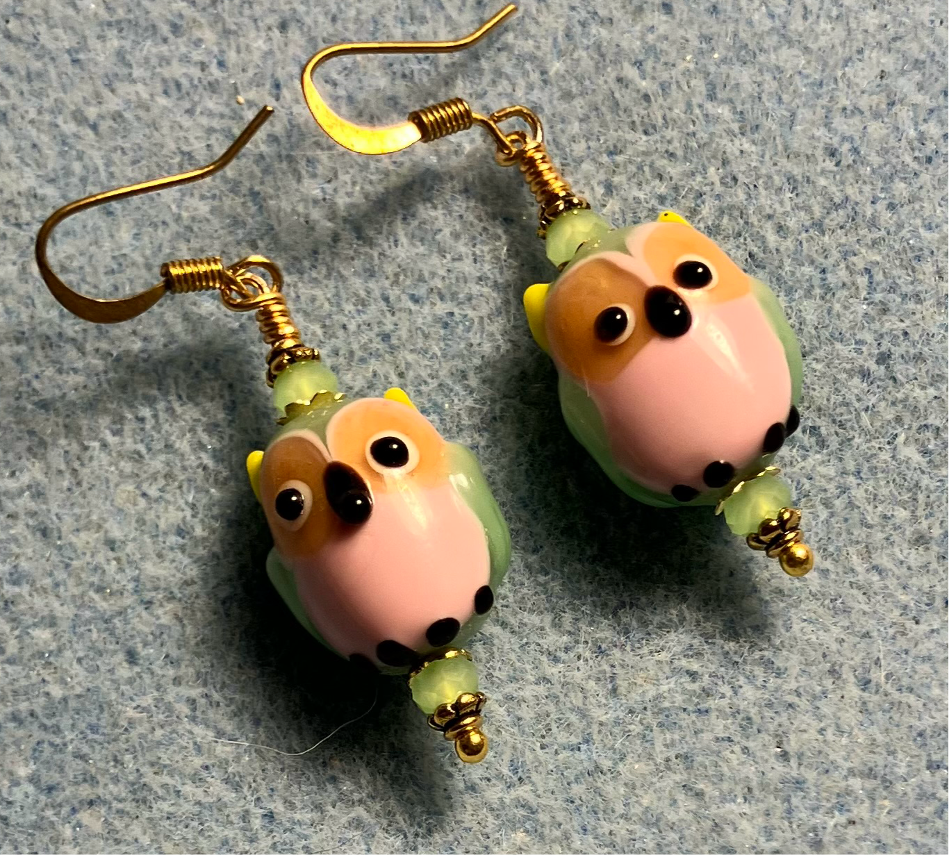 Pink and green lamp work owl bead earrings adorned with green Chinese crystal beads.