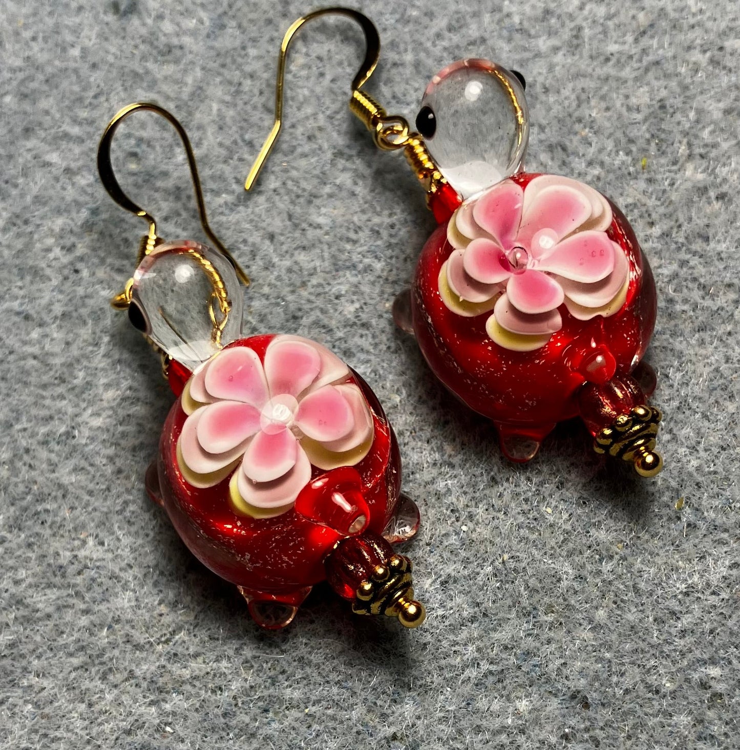 Large red and pink lamp work turtle bead earrings adorned with red Czech glass beads.