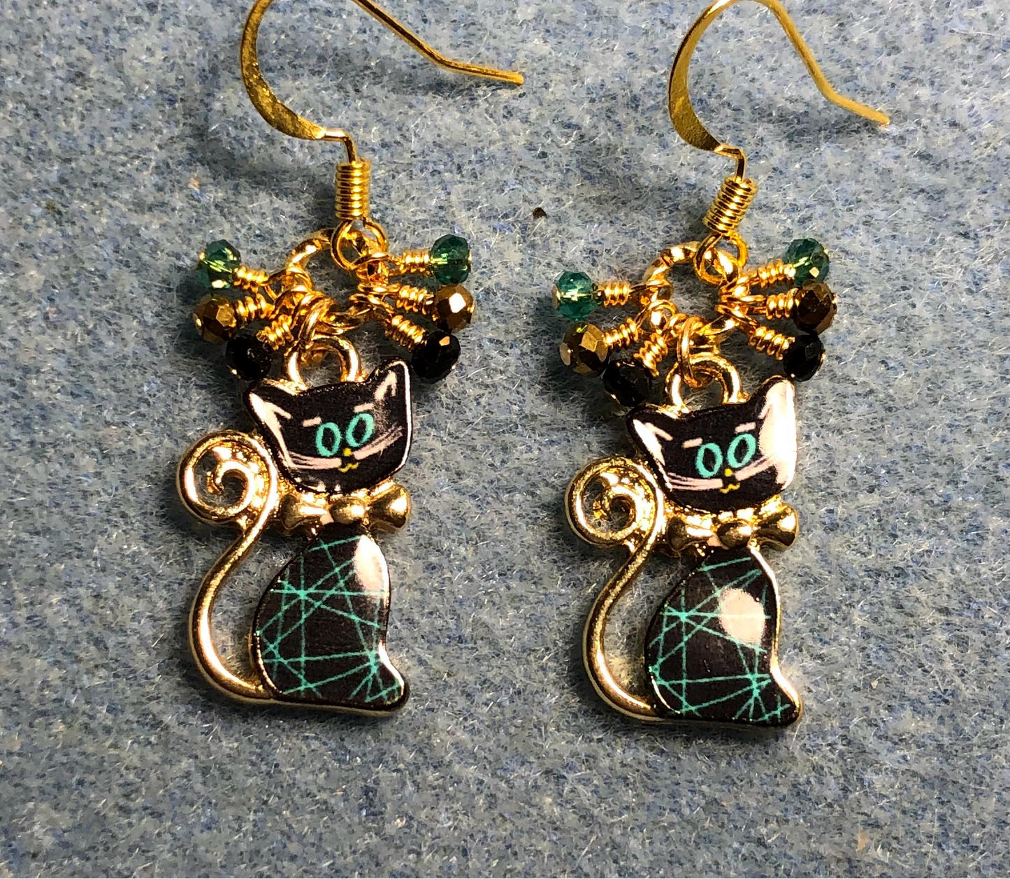 Teal, black, and gold enamel cat charm earrings adorned with small dangling teal, black, and gold Chinese crystal beads.