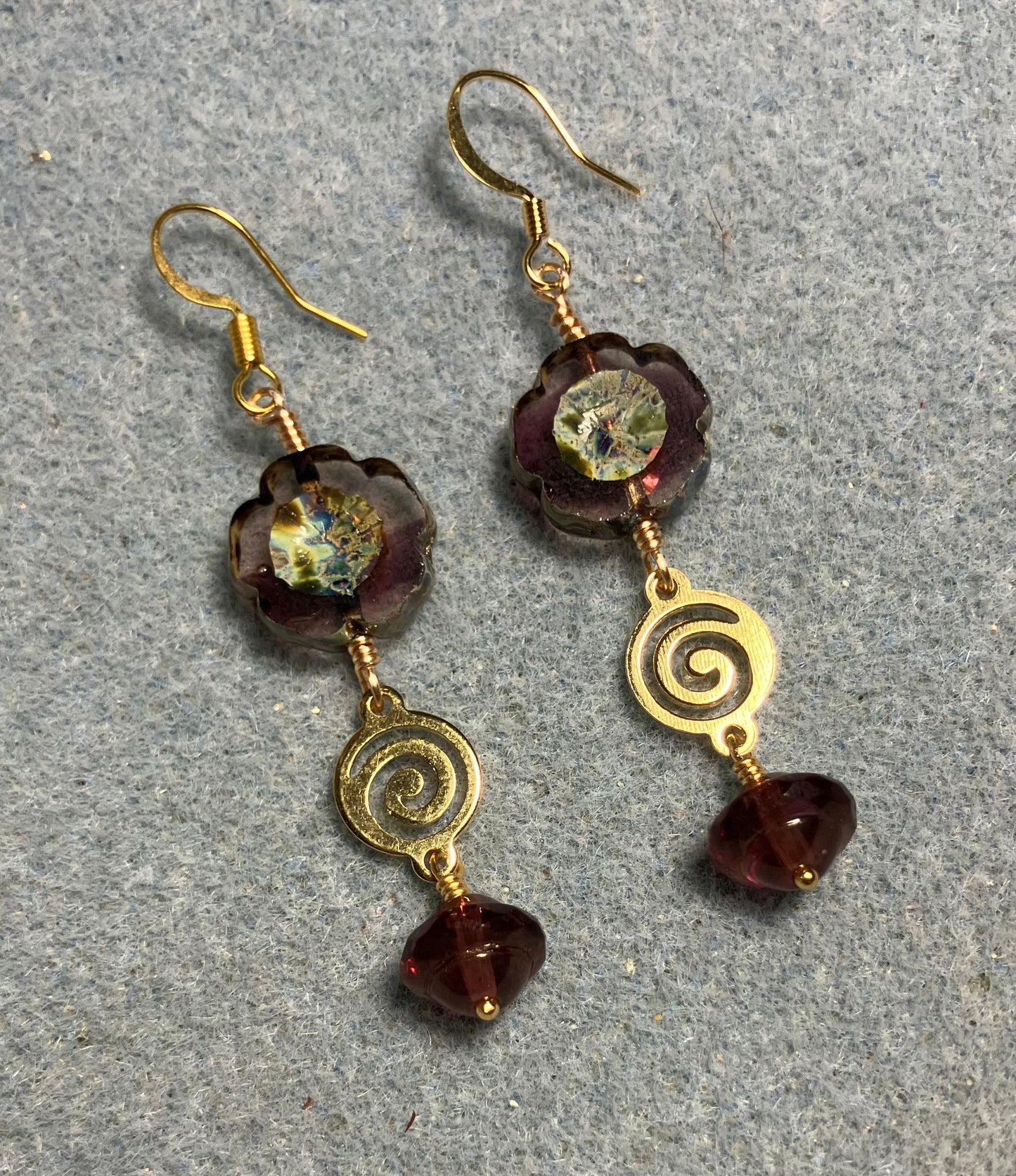 Translucent violet Czech glass pansy bead earrings adorned with gold swirly connectors and violet Czech glass Saturn beads.