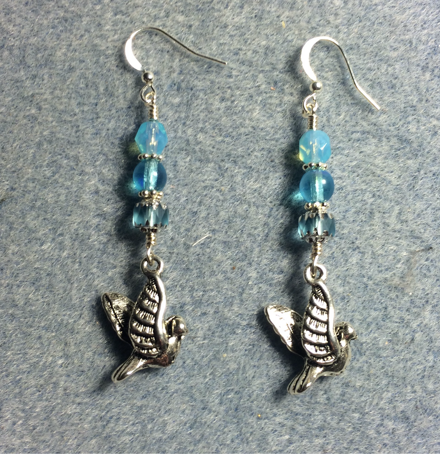 Silver flying dove charm earrings adorned with light turquoise Czech glass beads