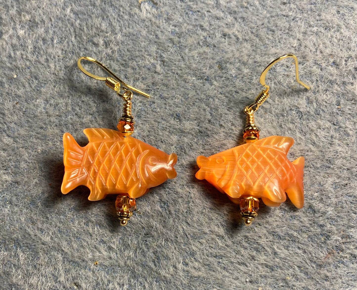 Orange fiber optic (cat’s eye) gemstone fish bead earrings adorned with orange Chinese crystal beads.